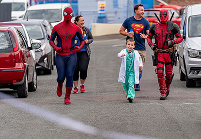 Superheroes running down a street