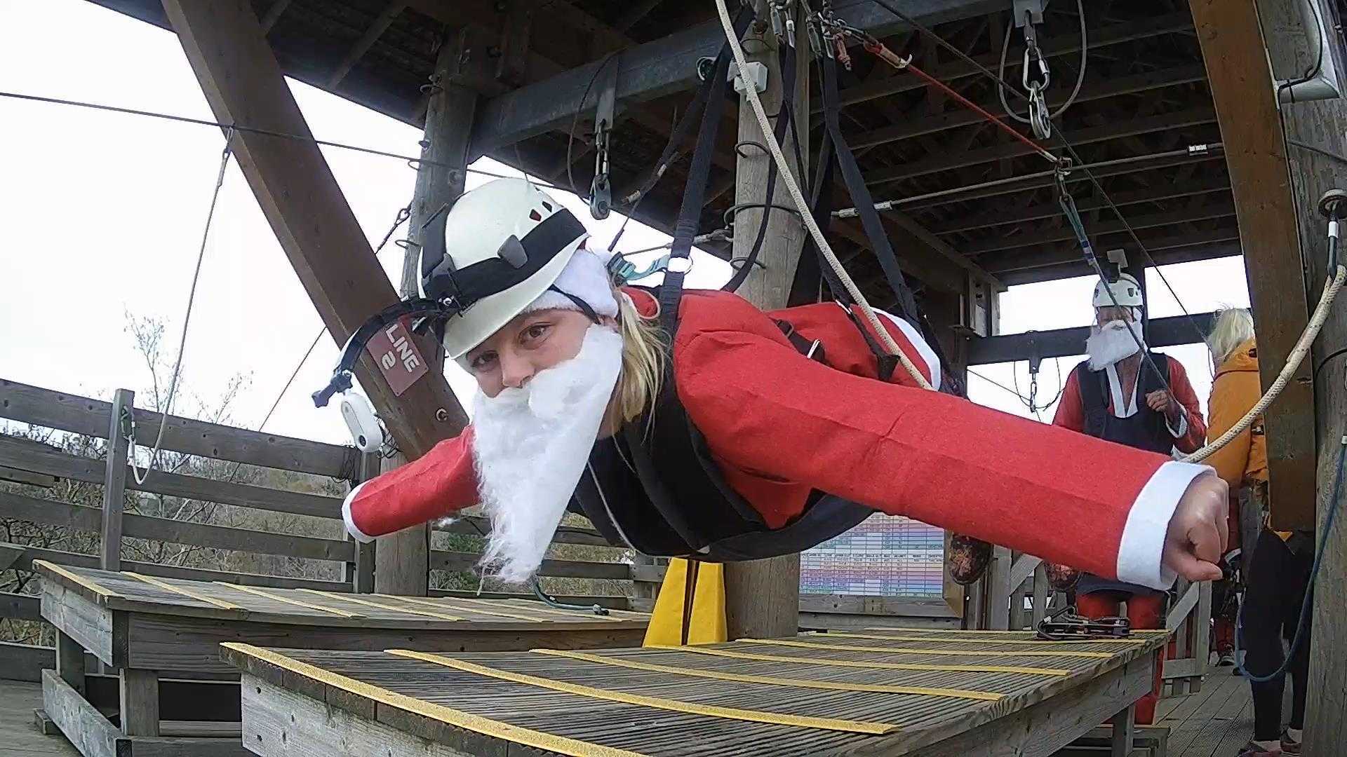person in santa suit on zip wire