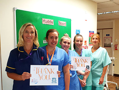 Group of nurses hold up a Thank You sign