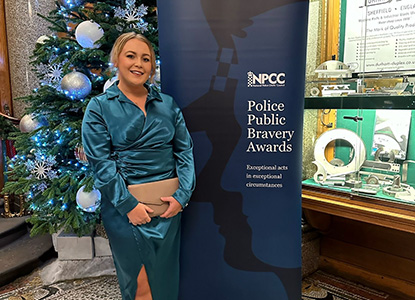 Gemma Wellman, a Renal Transplant Nurse Specialist at UHP, in front of a promotional banner at the Police Public Bravery Award ceremony