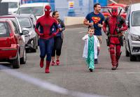 Superheroes running down a street