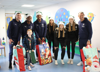 Argyle players with patient and gift bags