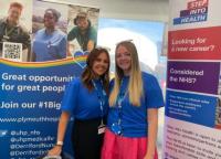 The recruitment team standing in front of their recruitment branded materials