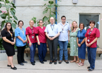 Dr Nikitas and the ICU team outside with plants behind them